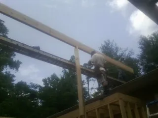 Carpenter setting a ridge beam over a new addition frame — Ice Dam Removal by Roofing Brothers in Eastview