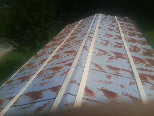 Rusted metal roof panels with new wood purlins before replacement — Storm Damage Roof Repair in Eastview by Roofing Brothers