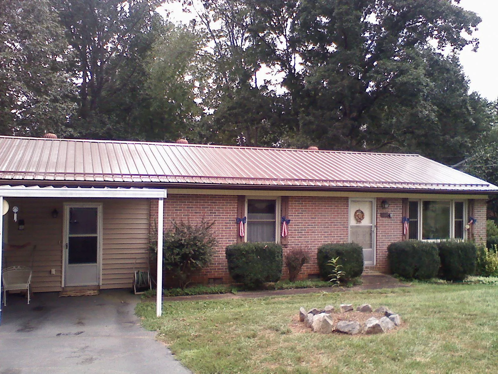 Bronze metal roof and carport on a brick ranch home — Roof Repair work by our crew in Eastview